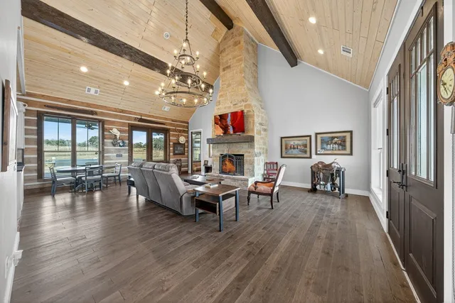 a living room with furniture a fireplace and a chandelier