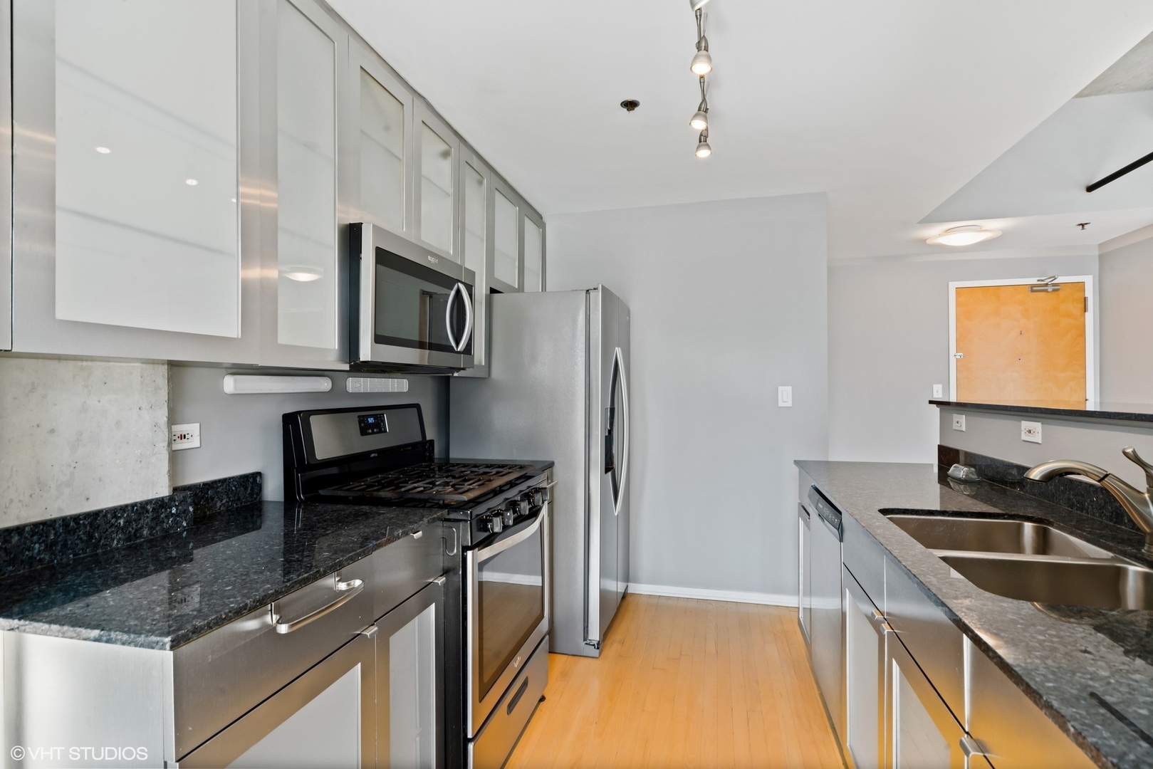 700 West Van Buren Street, Unit PH3 Chicago, IL 60607 - Photo 5 of 20 a kitchen with kitchen island granite countertop a sink stove and refrigerator