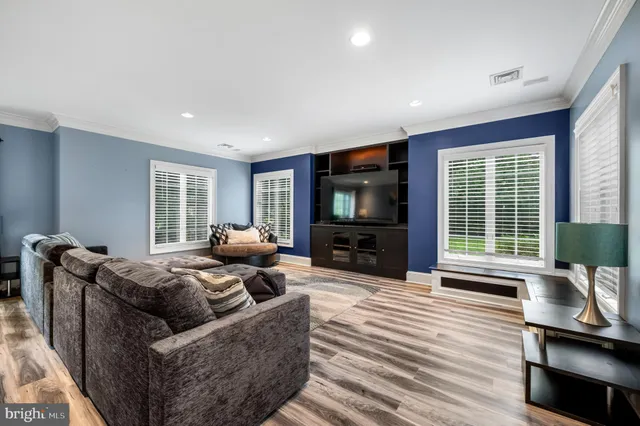 a living room with furniture a flat screen tv and a large window