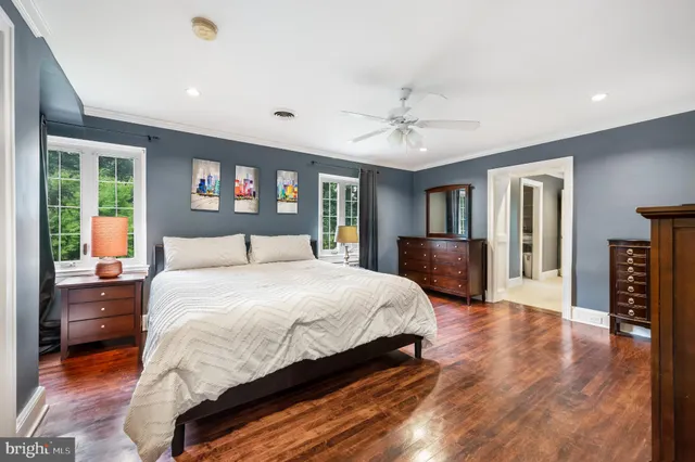 a bedroom with a large bed a flat tv screen and dresser
