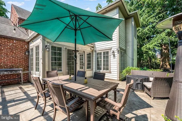 a patio with a table and chairs under an umbrella