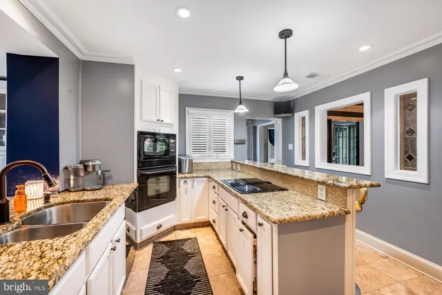 a kitchen that has a sink a stove and a wooden floor
