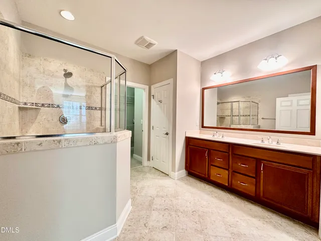a spacious bathroom with a granite countertop sink mirror and a bathtub