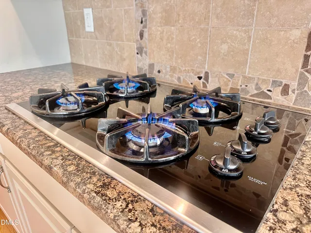 a kitchen with granite countertop a refrigerator stove and microwave