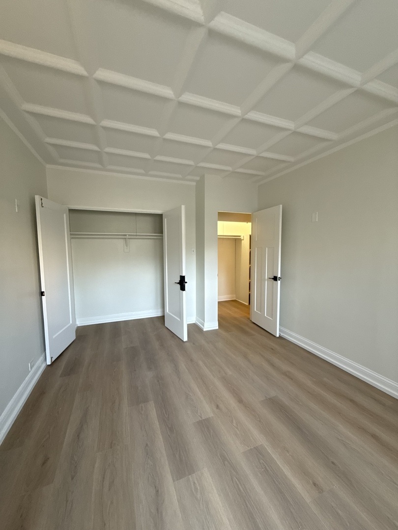 1211 North LaSalle Drive, Unit 401 Chicago, IL 60610 - Photo 4 of 15 a view of an empty room and window and wooden floor