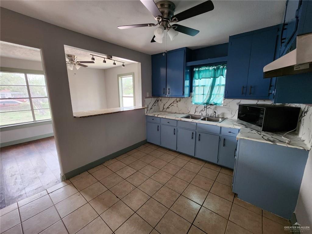 2002 Thornton Street Mission, TX 78572 - Photo 14 of 20 a kitchen with a sink a stove cabinets and a window