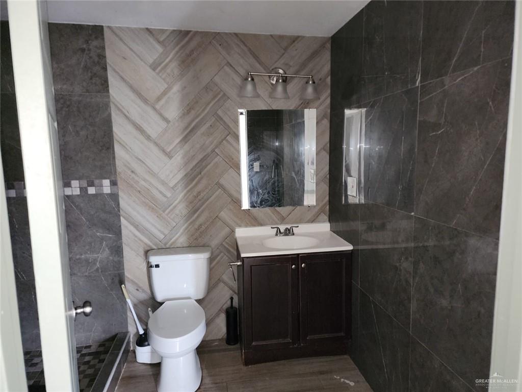 2002 Thornton Street Mission, TX 78572 - Photo 4 of 20 a bathroom with a toilet sink and mirror