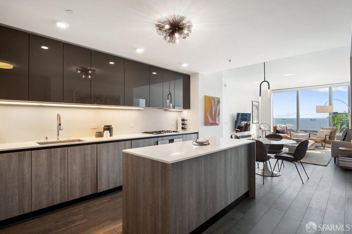 201 Folsom Street, Unit 22F San Francisco, CA 94105 - Photo 13 of 53 a kitchen with stainless steel appliances granite countertop a sink counter space and wooden floor