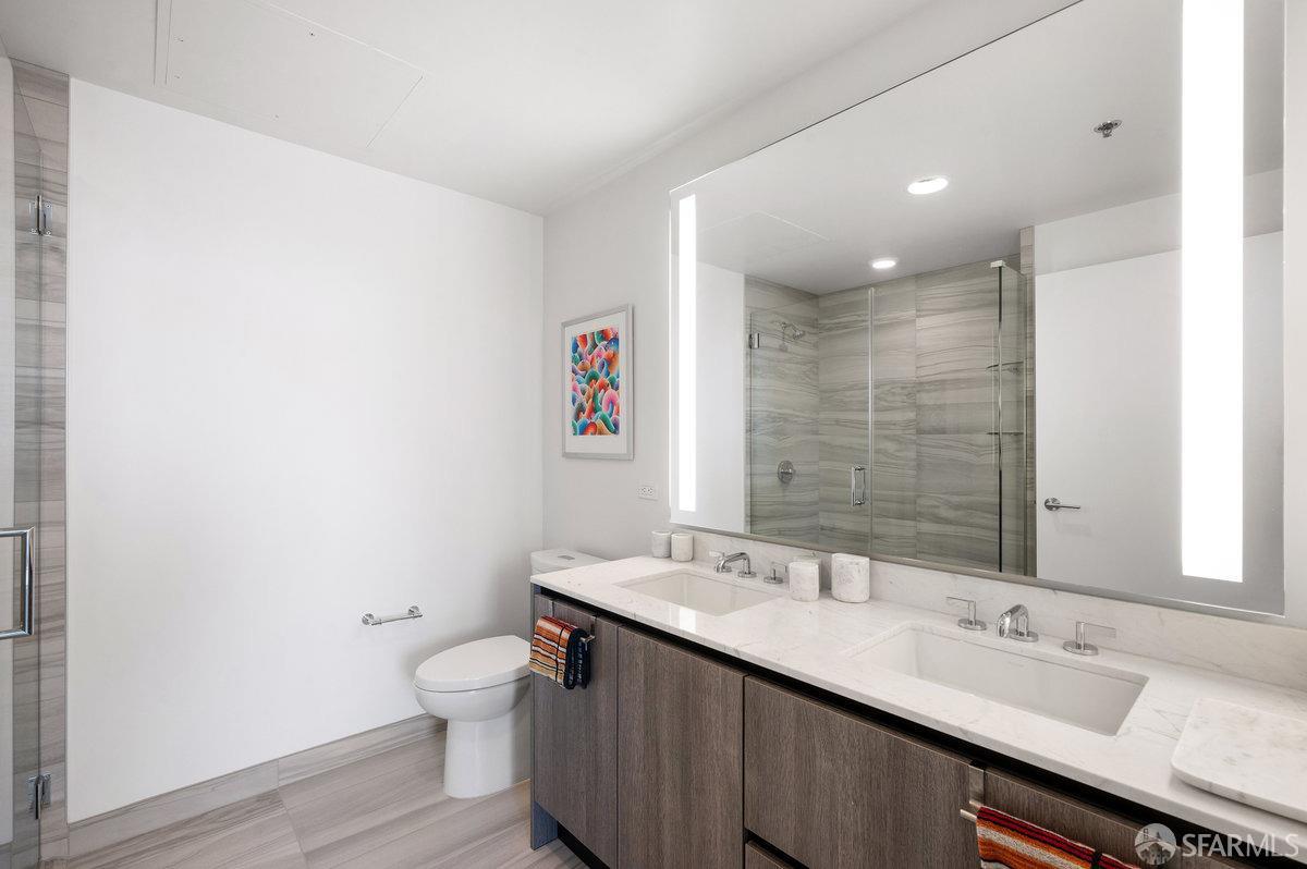 201 Folsom Street, Unit 22F San Francisco, CA 94105 - Photo 19 of 53 a bathroom with a granite countertop sink a toilet and a mirror