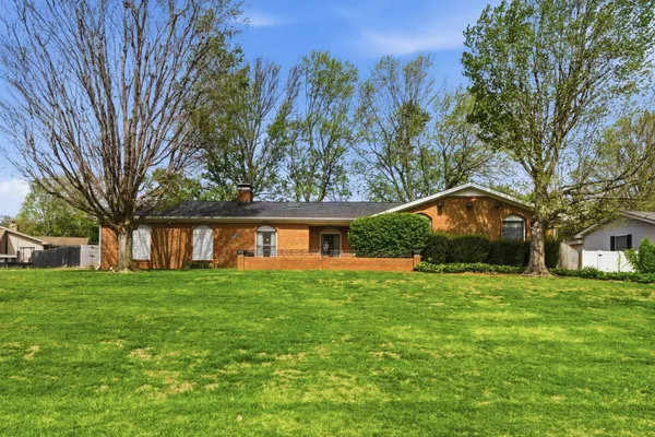 a front view of house with yard and trees