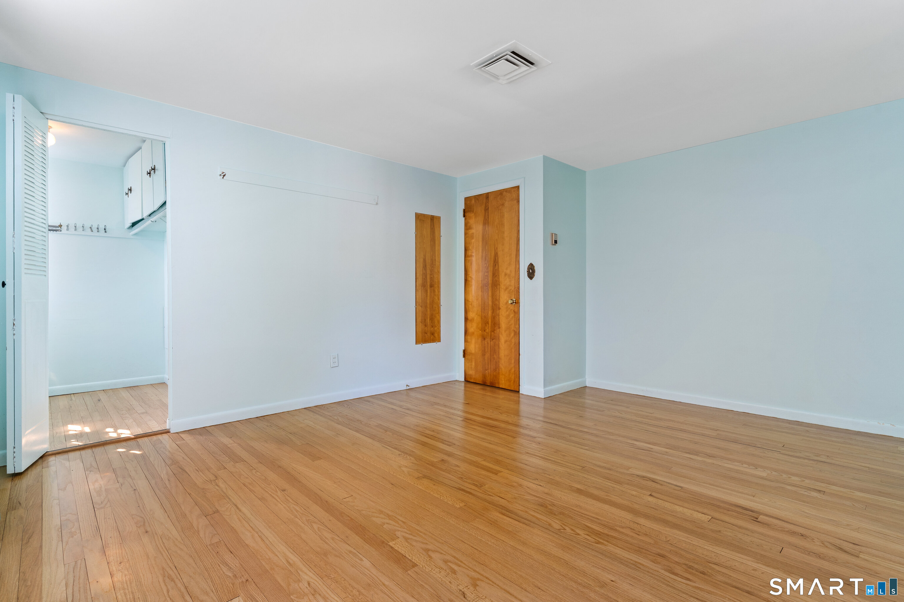251 Shelter Rock Road Fairfield, CT 06825 - Photo 23 of 38 a view of an empty room with wooden floor and a bathroom