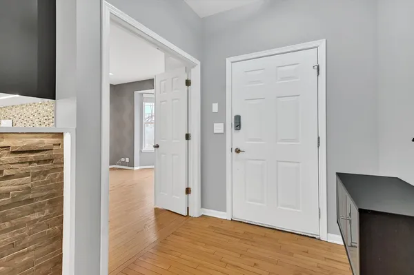 a view of an empty room with wooden floor and closet