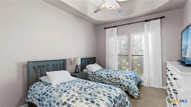 a bedroom with two beds and a large window