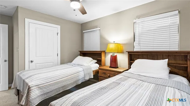 a bedroom with beds and lamp on table