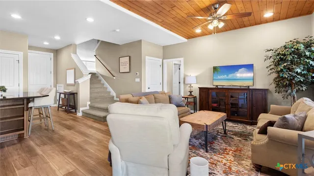 a living room with furniture a chandelier and a flat screen tv