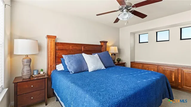 a bedroom with a bed and a lamp on the dresser