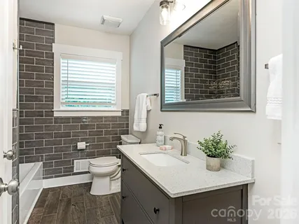 a bathroom with a sink toilet and window