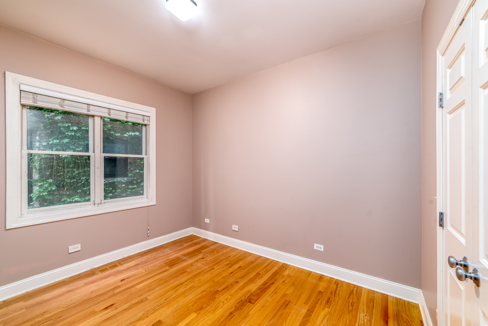 4425 North Racine Avenue, Unit 1S Chicago, IL 60640 - Photo 10 of 28 a view of empty room with wooden floor and fan