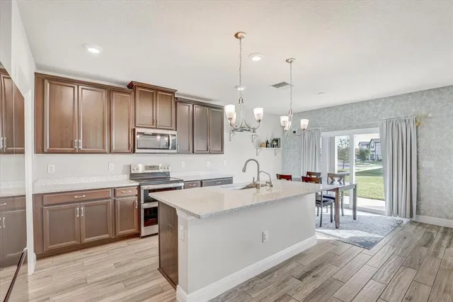 a large kitchen with kitchen island a sink stainless steel appliances and cabinets