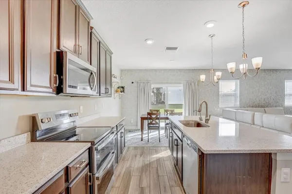 a kitchen with sink a refrigerator and chairs