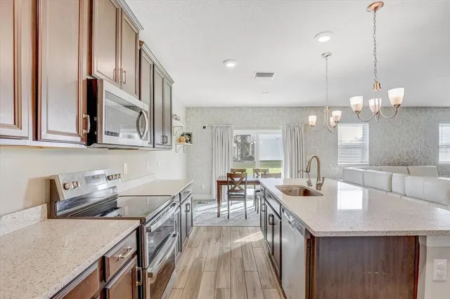 a kitchen with sink a refrigerator and chairs