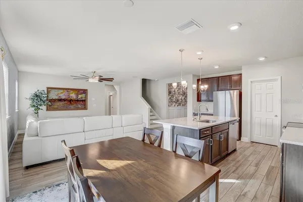 a living room with kitchen island a table and chairs in it