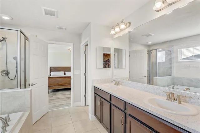 a spacious en suite bathroom with a double sink and mirror