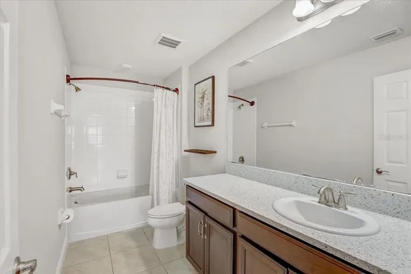 a bathroom with a granite countertop sink toilet a shower and a mirror