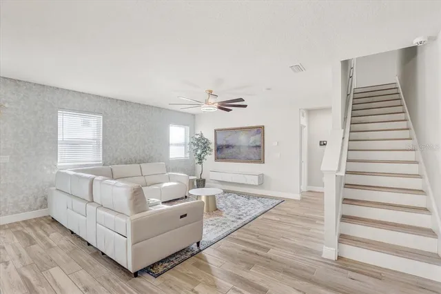 a living room with furniture and wooden floor