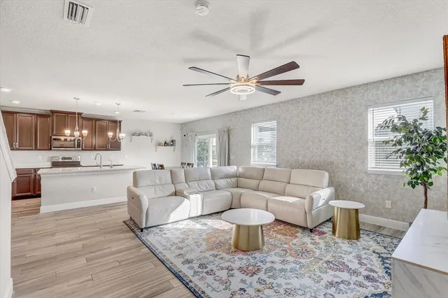 a living room with furniture a chandelier and a table