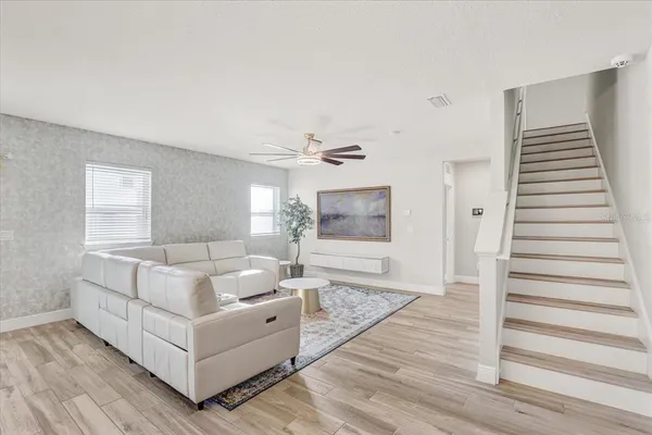 a living room with furniture and wooden floor