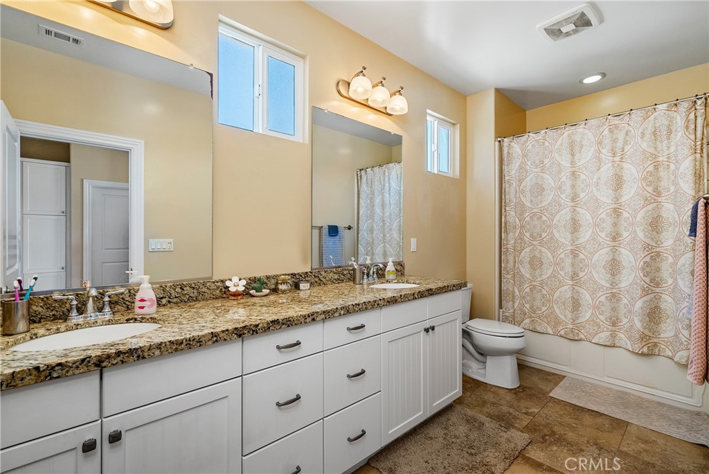 419 Junipero Way San Luis Obispo, CA 93401 - Photo 17 of 29 a bathroom with a granite countertop sink toilet and a mirror