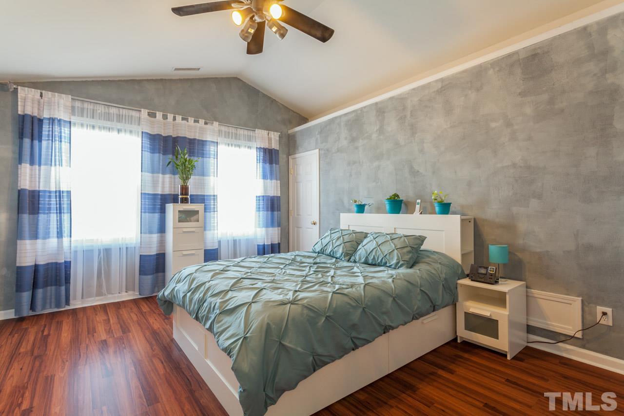 4004 Iverson Street Raleigh, NC 27604 - Photo 14 of 24 a bedroom with a bed and a chandelier