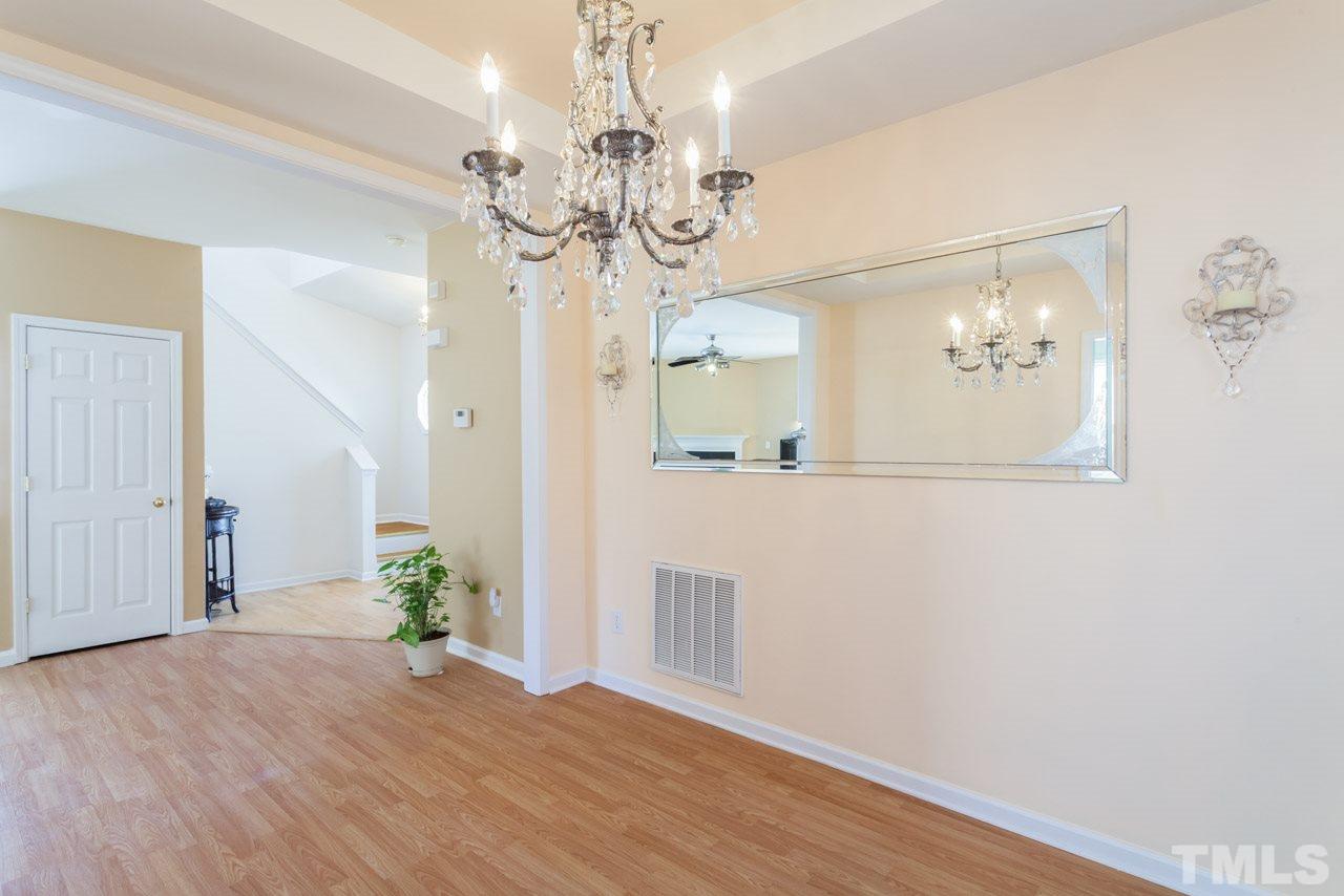4004 Iverson Street Raleigh, NC 27604 - Photo 6 of 24 a view of a hallway with wooden floor and chandelier