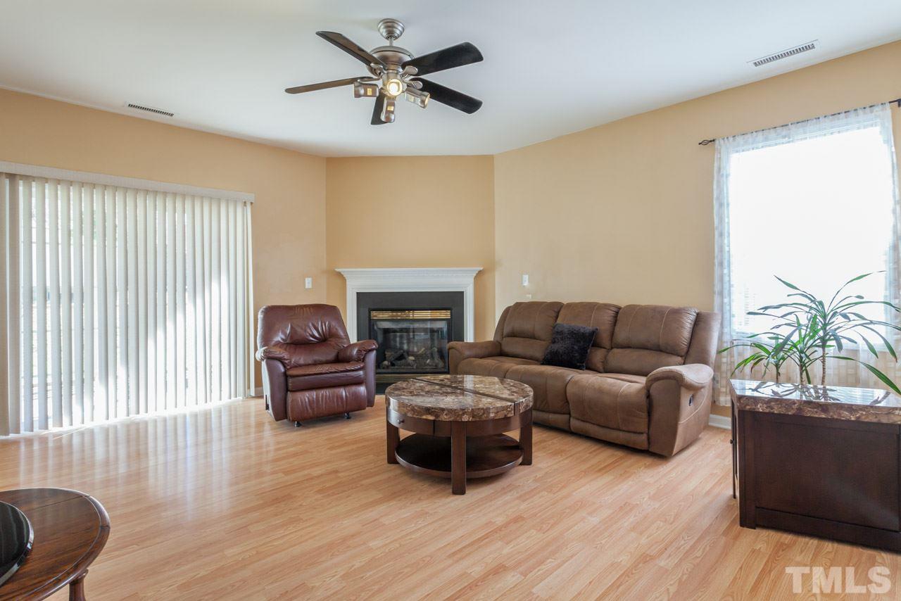 4004 Iverson Street Raleigh, NC 27604 - Photo 8 of 24 a living room with furniture a fireplace and a large window