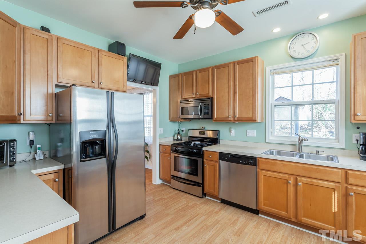 4004 Iverson Street Raleigh, NC 27604 - Photo 10 of 24 a kitchen with stainless steel appliances granite countertop a stove a sink dishwasher a refrigerator and a microwave oven with wooden floor
