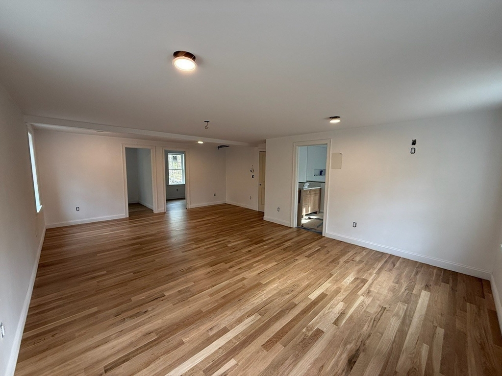 120 Maple Street Stow, MA 01775 - Photo 20 of 36 a view of empty room with wooden floor and window