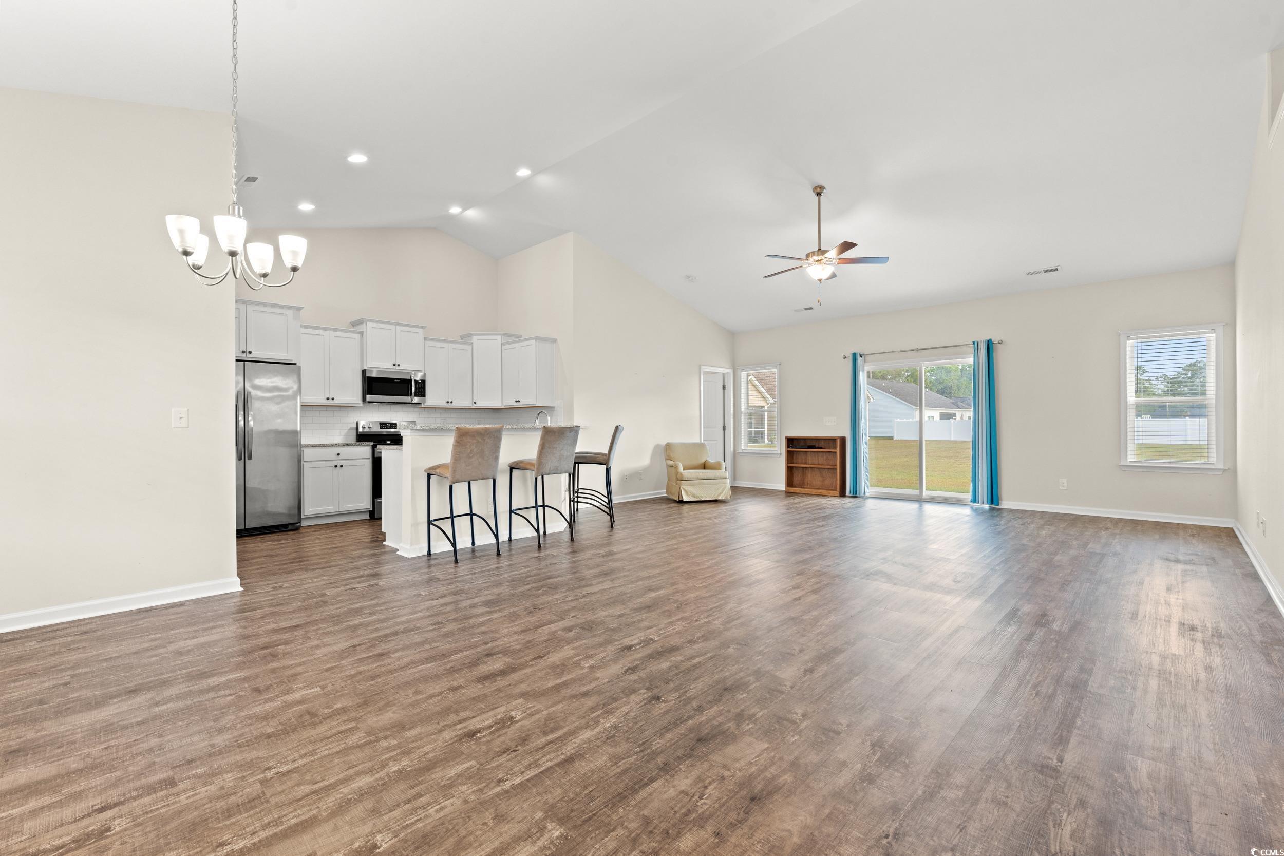 327 Fox Bay Road Loris, SC 29569 - Photo 3 of 23 Living area featuring dark wood-type flooring, high vaulted ceiling, a chandelier, and a ceiling fan