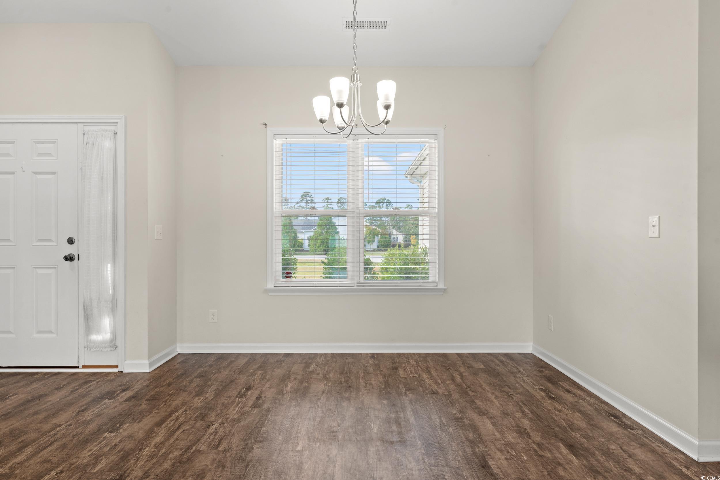 327 Fox Bay Road Loris, SC 29569 - Photo 5 of 23 Unfurnished dining area featuring dark wood-style flooring and a chandelier. This is also the entryway.