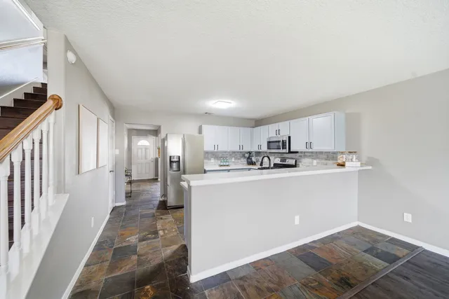 a view of a kitchen with kitchen island wooden floor center island stainless steel appliances and view living room