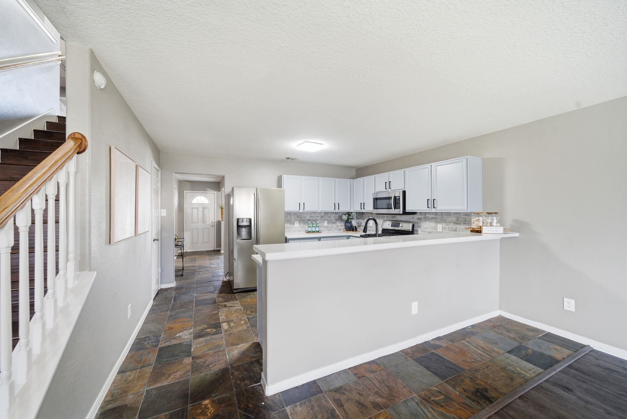 14422 Leafy Tree Drive Houston, TX 77090 - Photo 11 of 40 a view of a kitchen with kitchen island wooden floor center island stainless steel appliances and view living room