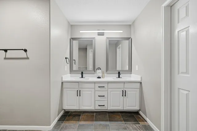 a bathroom with a double vanity sink and mirror