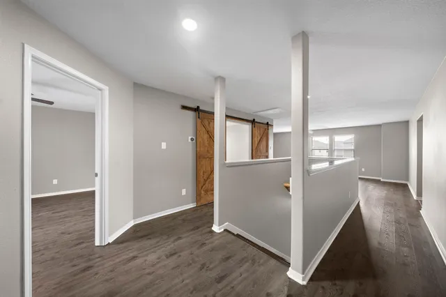 a view of a hallway with wooden floor