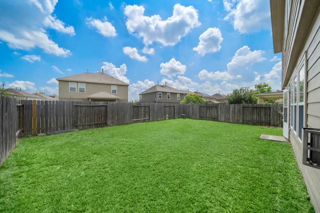 a view of a backyard with wooden fence