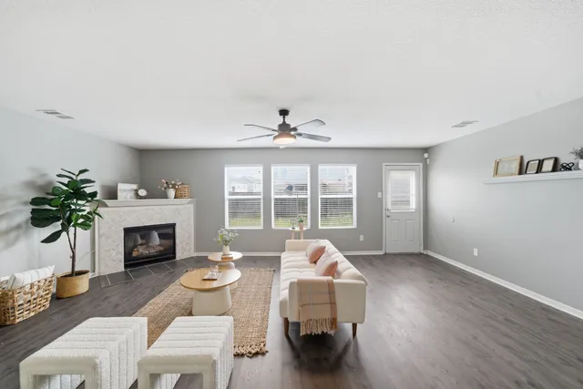 a living room with furniture a fireplace and a large window