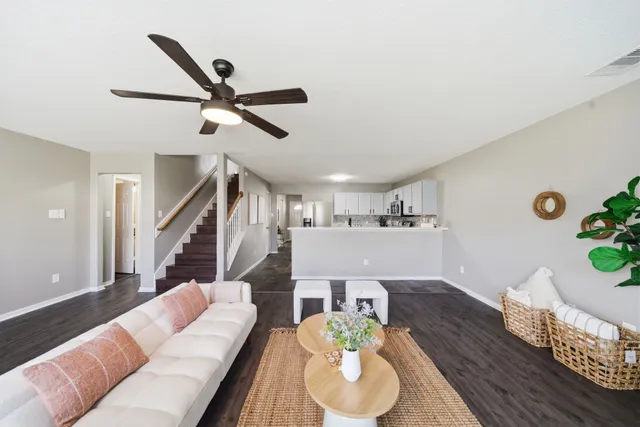 a living room with furniture and a wooden floor