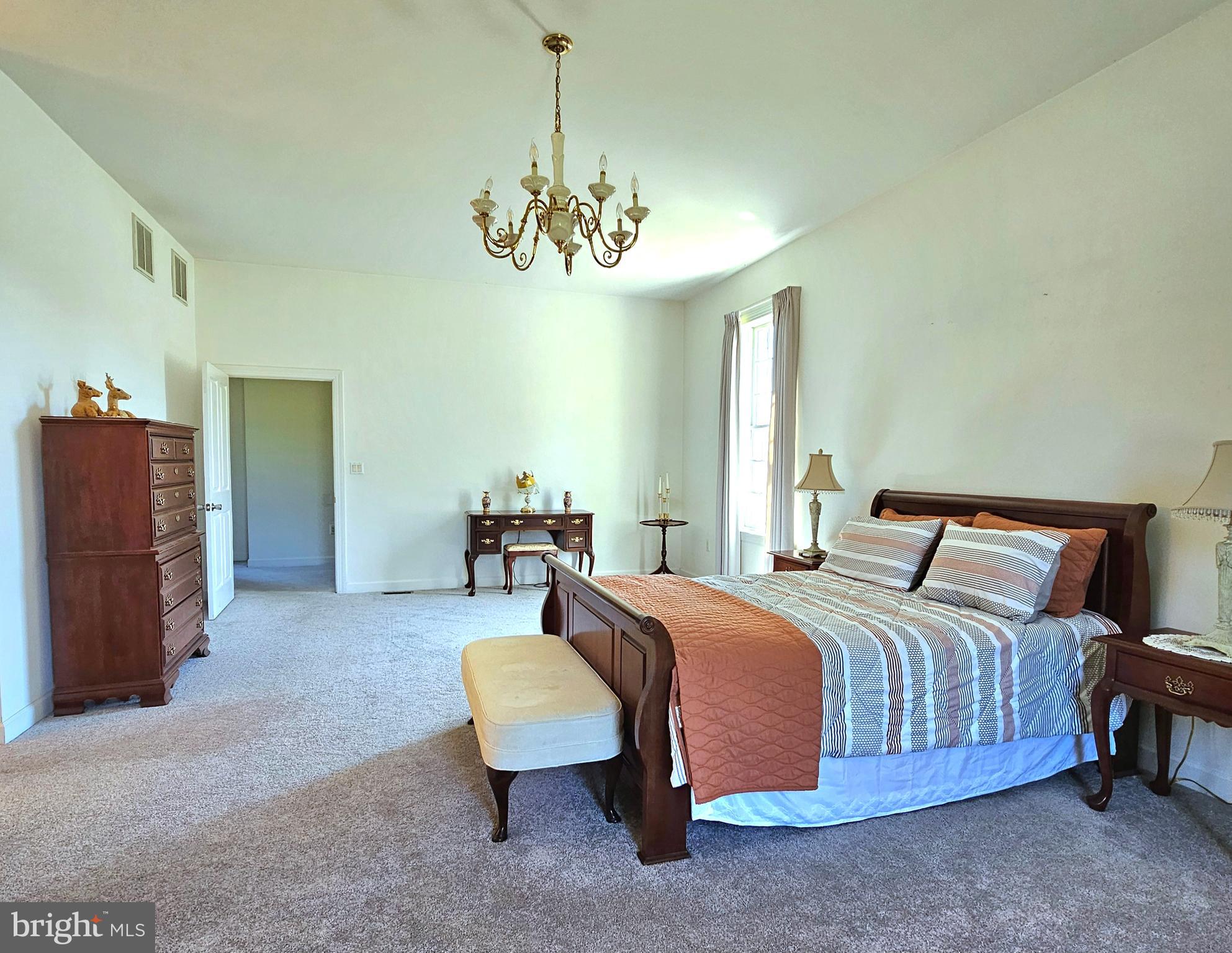 13212 Beaver Dam Road Cockeysville, MD 21030 - Photo 28 of 55 a spacious bedroom with a bed a chandelier and a dresser