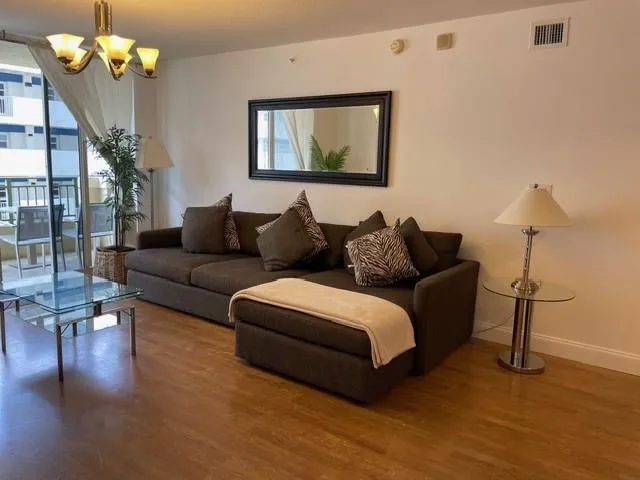 a living room with furniture a potted plant and a window