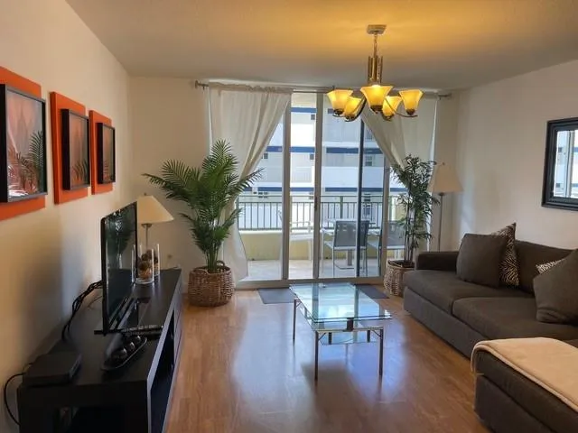 a living room with furniture flowerpot and a chandelier