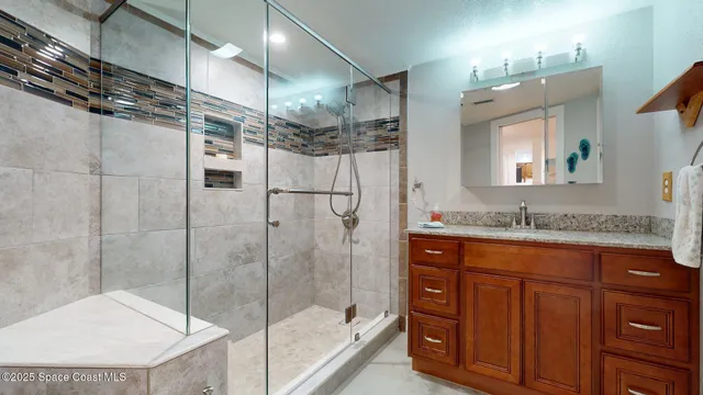 a bathroom with a granite countertop sink a toilet and shower